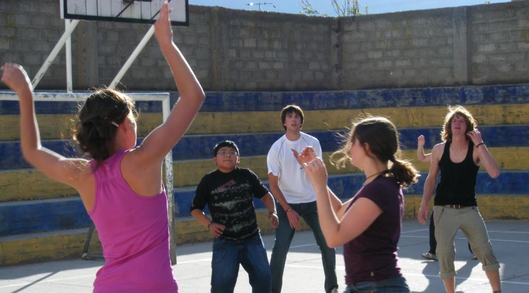A Projects Abroad volunteer teaches how to defend a basketball hoop while getting sports coaching work experience in Peru A volunteer coaching sports in schools in Peru demonstrates for her team